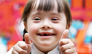 Little girl with special needs giving thumbs up